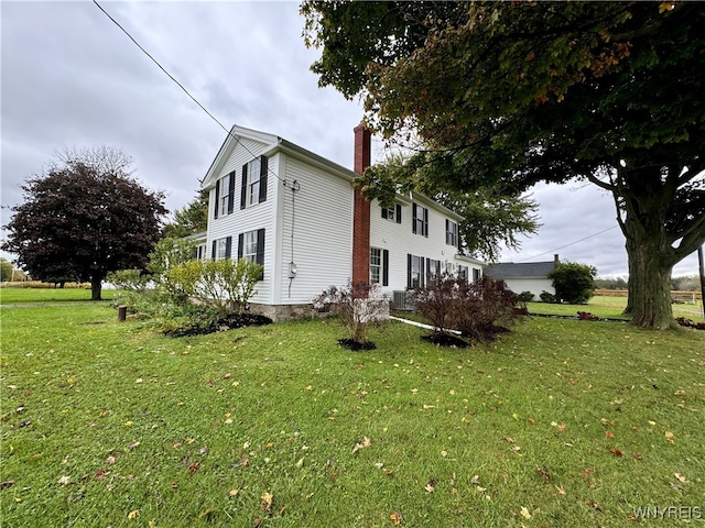 view of side of home with a yard and central AC unit