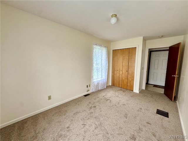 unfurnished bedroom with light carpet and a closet