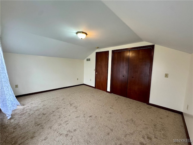 bonus room with lofted ceiling and carpet flooring