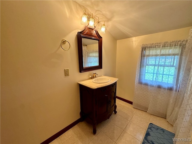 bathroom featuring vanity, tile patterned floors, and lofted ceiling