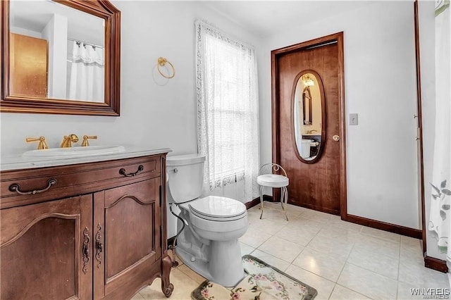 bathroom with toilet, vanity, and tile patterned floors