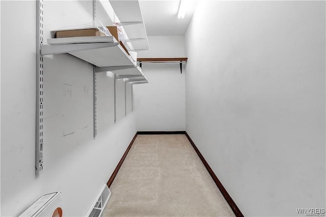 walk in closet featuring light carpet