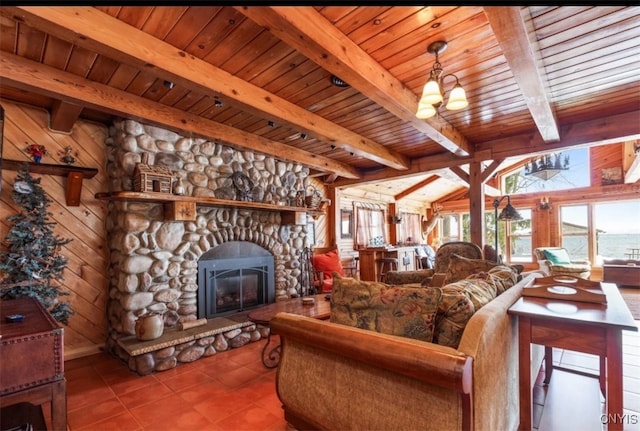 living room featuring beamed ceiling, wooden ceiling, wooden walls, a fireplace, and light tile patterned floors