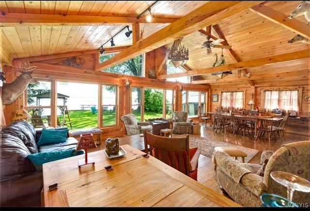 living room with ceiling fan, wood ceiling, beam ceiling, wood-type flooring, and wooden walls