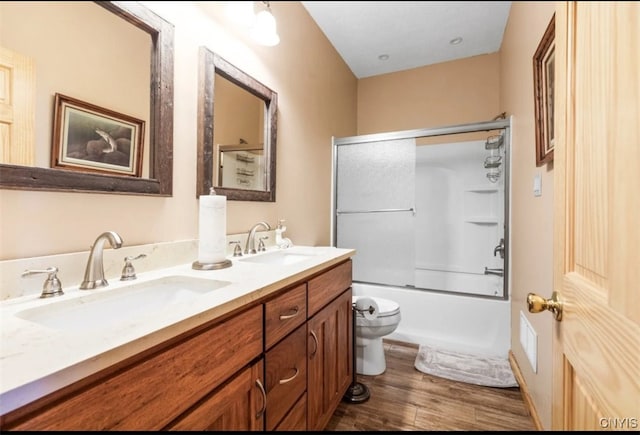 full bathroom featuring hardwood / wood-style floors, shower / bath combination with glass door, toilet, and vanity