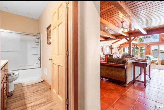 hall featuring beamed ceiling, wood ceiling, and tile patterned flooring