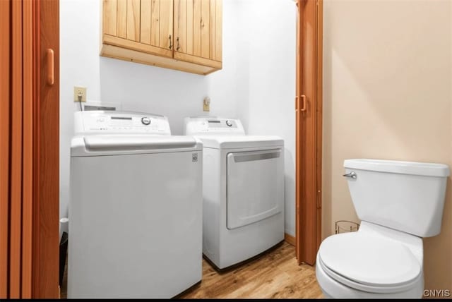 washroom with washer and dryer and light hardwood / wood-style flooring