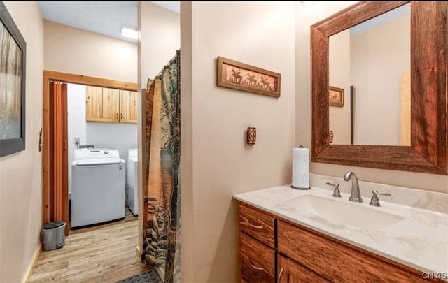 bathroom with washing machine and dryer, hardwood / wood-style flooring, toilet, and vanity