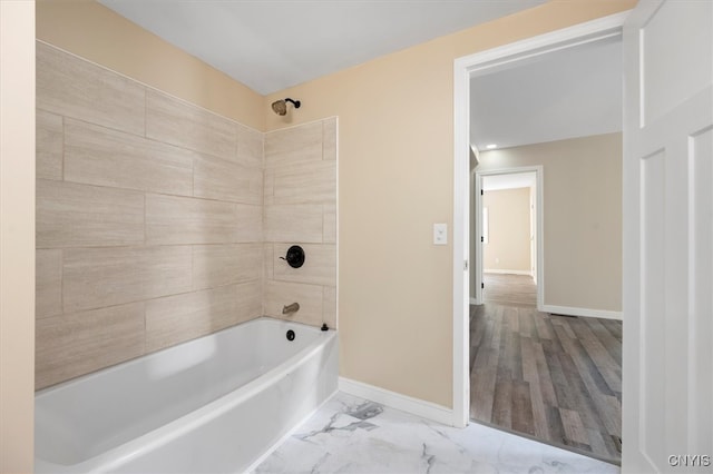 bathroom with hardwood / wood-style flooring and tiled shower / bath combo