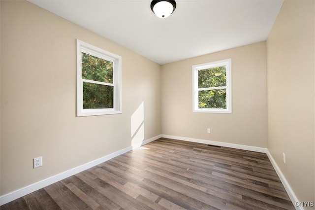 unfurnished room with a wealth of natural light and dark hardwood / wood-style floors