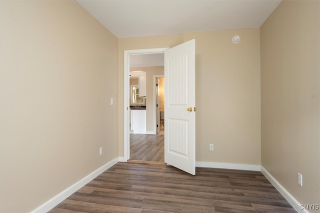 empty room with dark hardwood / wood-style flooring