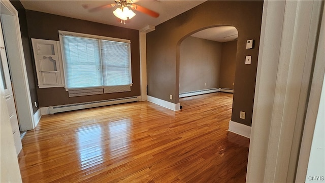 spare room with light hardwood / wood-style floors, baseboard heating, and ceiling fan