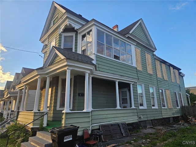 view of side of property featuring covered porch