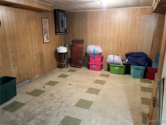 basement featuring electric panel and wooden walls