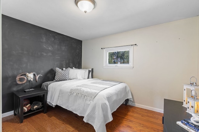 bedroom with dark hardwood / wood-style flooring