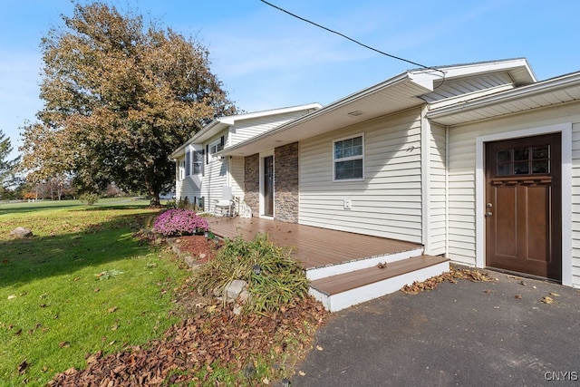 view of front of home with a deck and a front yard