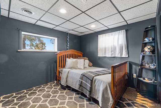 carpeted bedroom featuring a paneled ceiling