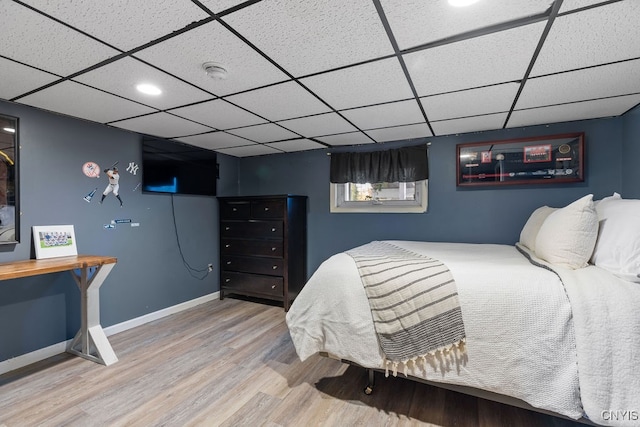 bedroom with a drop ceiling and hardwood / wood-style floors