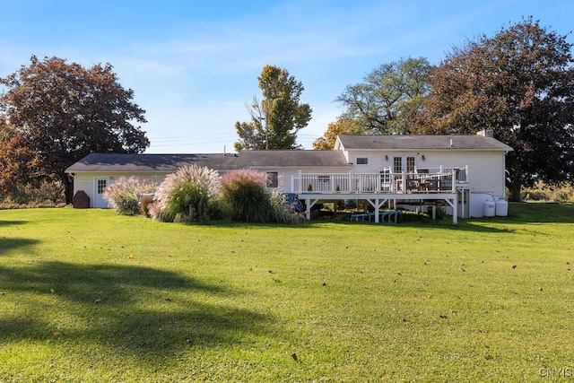 back of property featuring a lawn and a deck