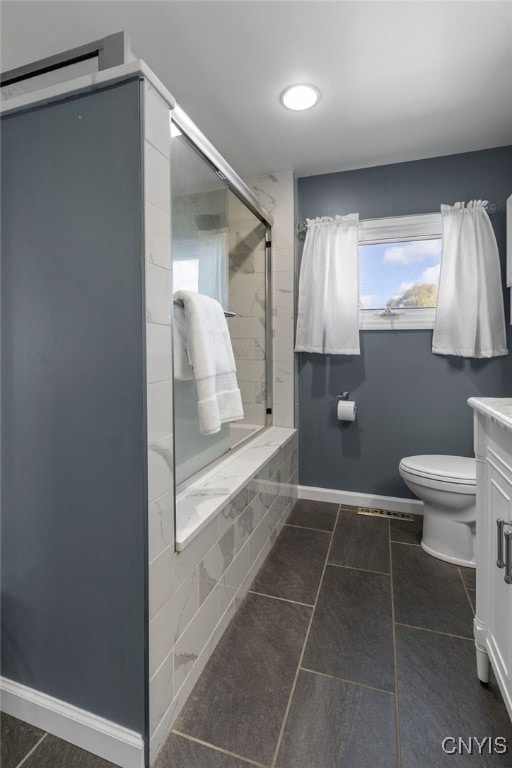 bathroom featuring vanity, toilet, an enclosed shower, and tile patterned floors