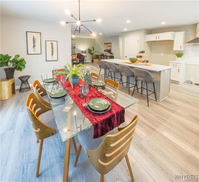 dining area featuring an inviting chandelier and light wood-type flooring