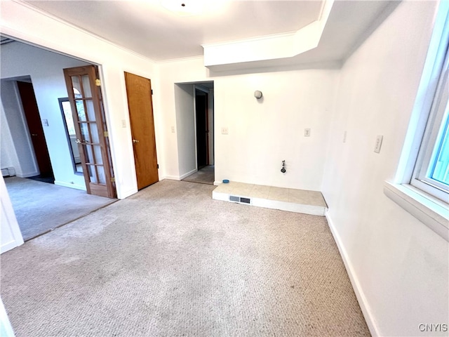 carpeted spare room with a baseboard radiator and crown molding