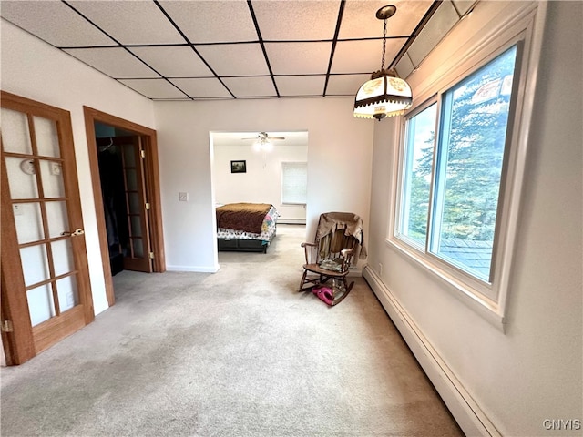 sitting room with ceiling fan, carpet, a paneled ceiling, and a baseboard heating unit