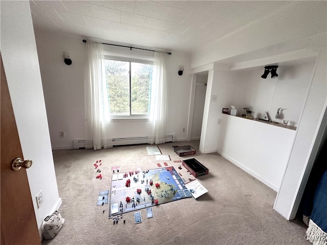 interior space featuring carpet flooring and a baseboard heating unit