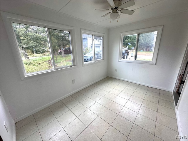 tiled spare room featuring ceiling fan and plenty of natural light