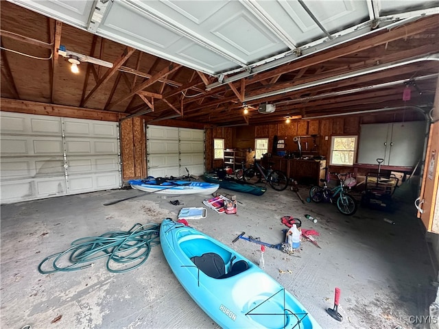 garage featuring a garage door opener and wooden walls