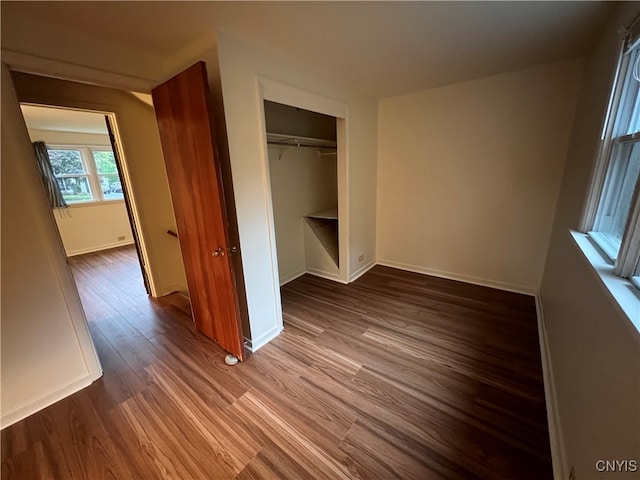 unfurnished bedroom with a closet and hardwood / wood-style floors