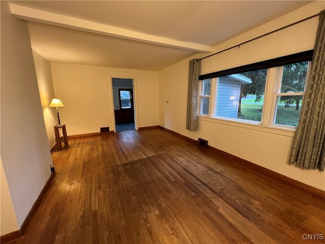 unfurnished room with beamed ceiling and dark hardwood / wood-style floors