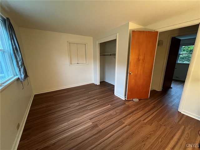 unfurnished bedroom featuring a closet and dark hardwood / wood-style floors