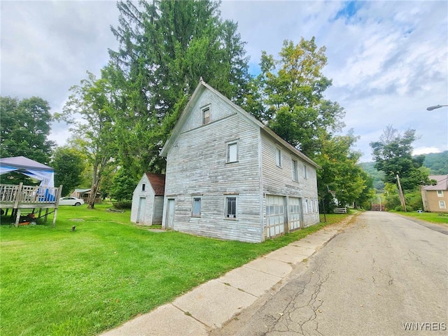 view of side of home featuring a yard and a deck