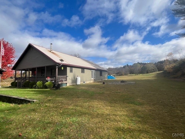 view of side of home with a lawn and covered porch