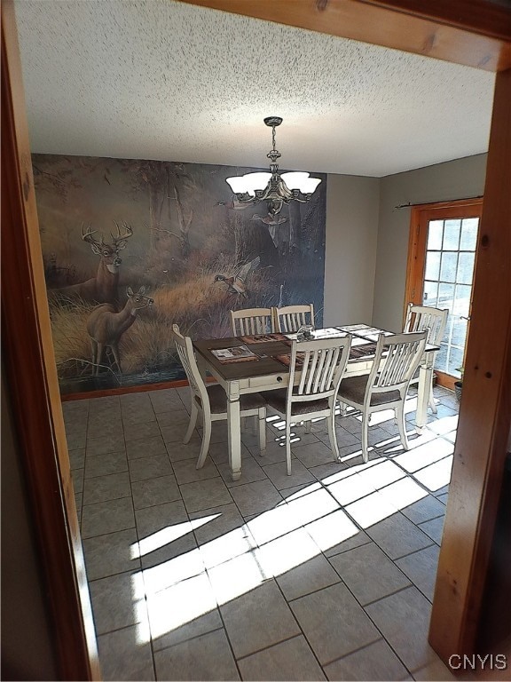 tiled dining room featuring a notable chandelier and a textured ceiling