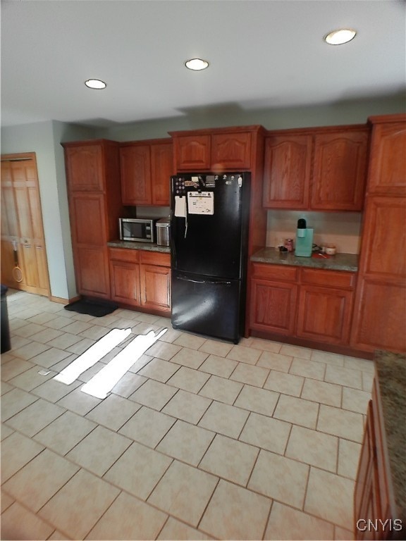 kitchen featuring black refrigerator and light tile patterned floors