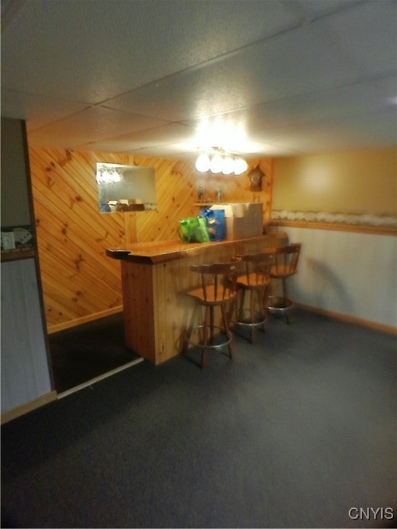 bar with wood walls and dark carpet