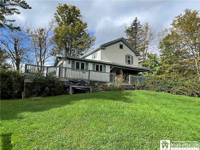 back of house with a wooden deck and a yard