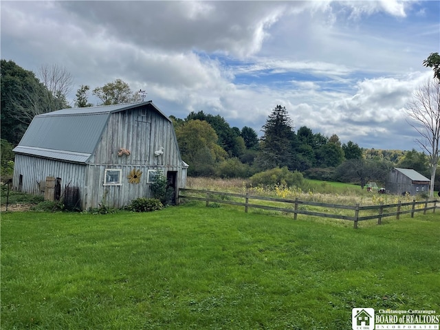 view of outbuilding featuring a rural view and a yard