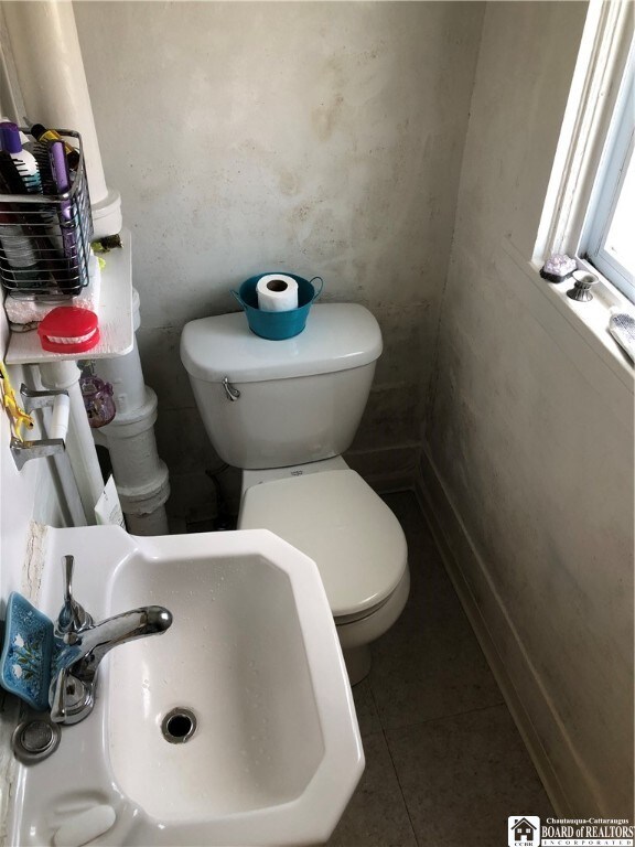 bathroom featuring toilet, sink, and tile patterned floors