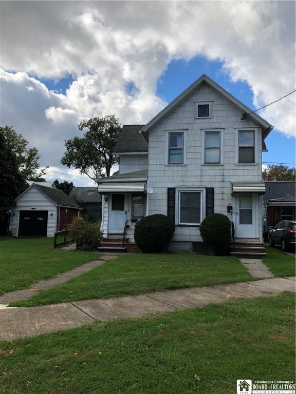 view of front of property featuring an outdoor structure, a front yard, and a garage