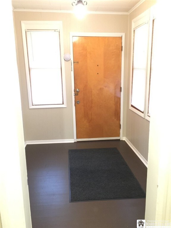 doorway to outside with ornamental molding and hardwood / wood-style floors