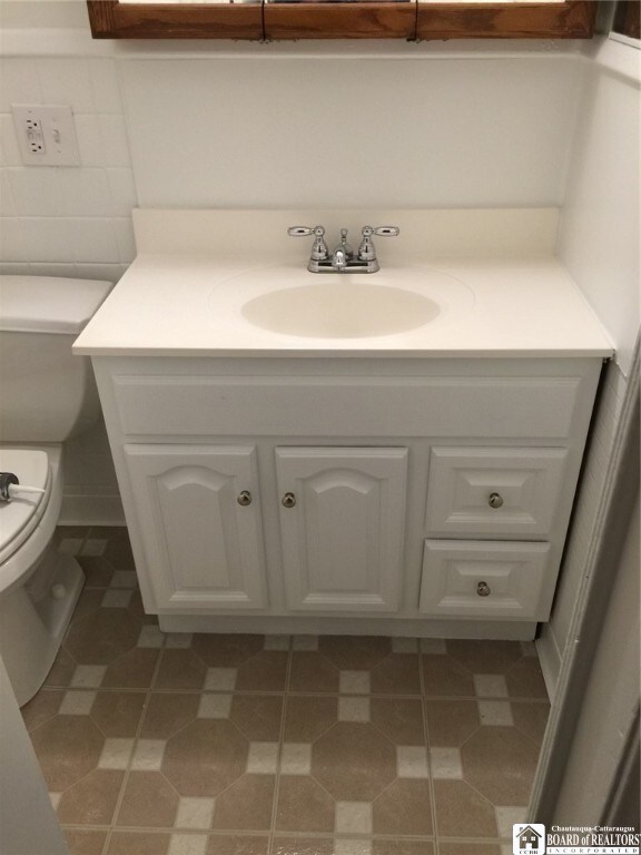 bathroom featuring vanity, toilet, and tile patterned flooring