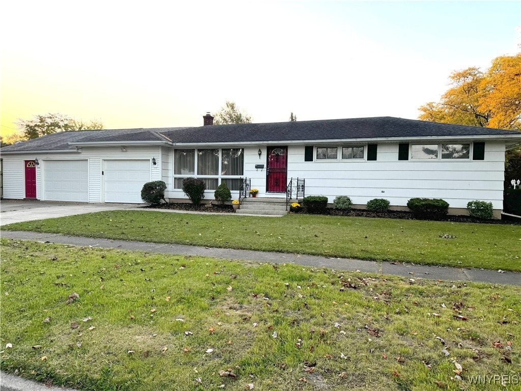 ranch-style home featuring a yard and a garage