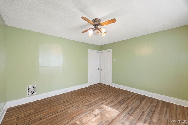 unfurnished room with ceiling fan, hardwood / wood-style floors, and a textured ceiling