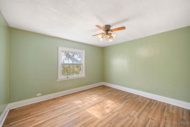 spare room with ceiling fan, light hardwood / wood-style flooring, and a textured ceiling