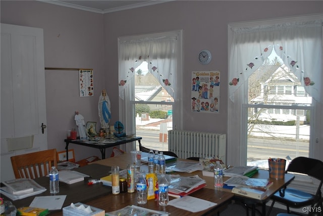 dining room with crown molding, hardwood / wood-style floors, and radiator heating unit