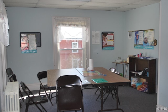 carpeted office with a drop ceiling and radiator heating unit