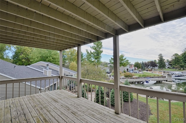 wooden deck with a dock and a water view